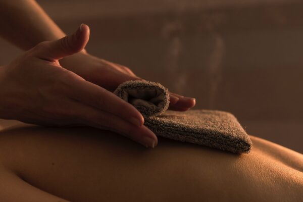 close-up-therapist-massaging-woman-s-back-with-hot-towel-beauty-spa